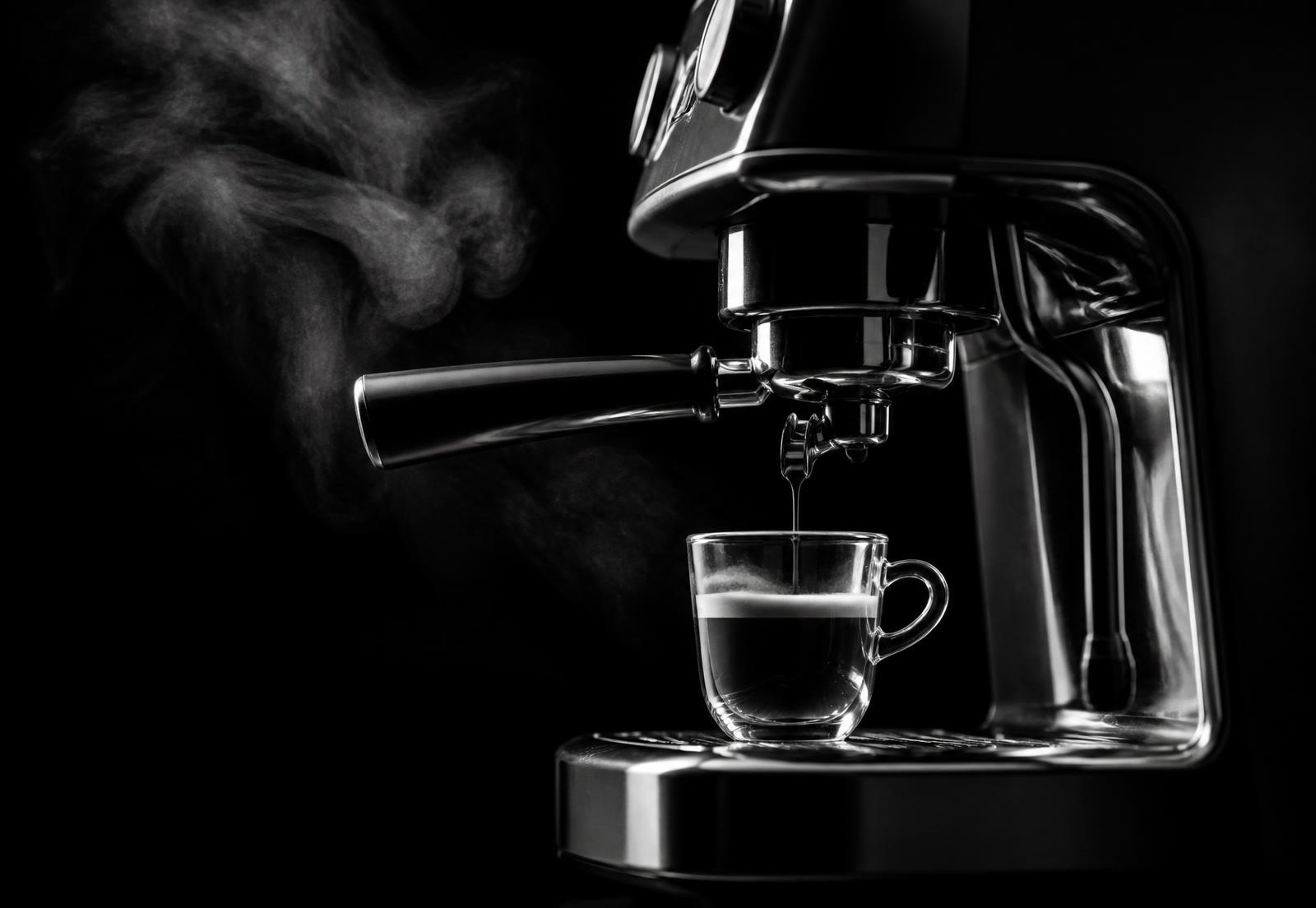 Espresso extrayéndose en una cafetera fotografiada en blanco y negro